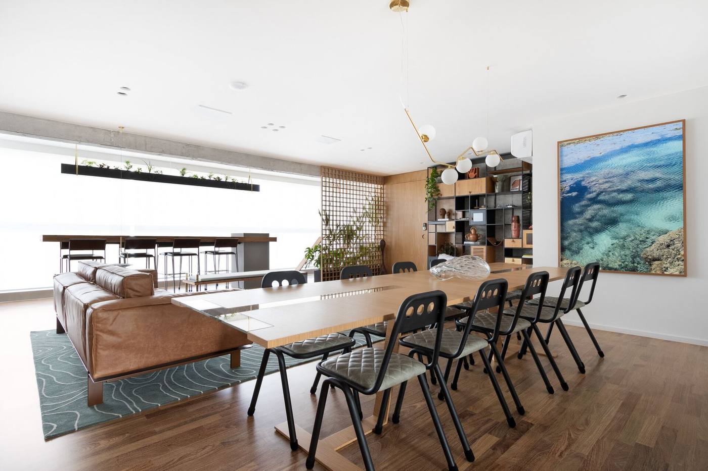 Sala de jantar integrada com mesa longa de madeira